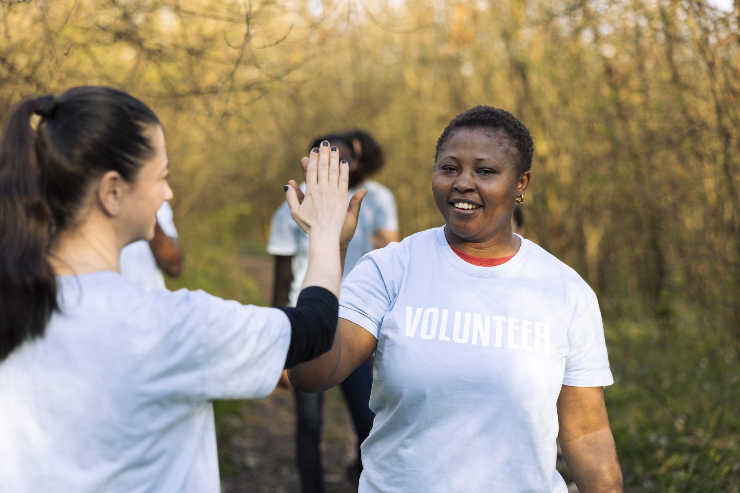 team leader sharing a high five with her colleague after litter cleanup activity